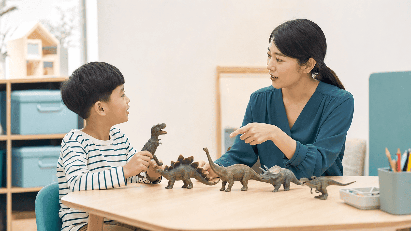 공룡 피규어를 사이에 두고 대화 순서를 연습하는 만 5세 아이와 언어치료사