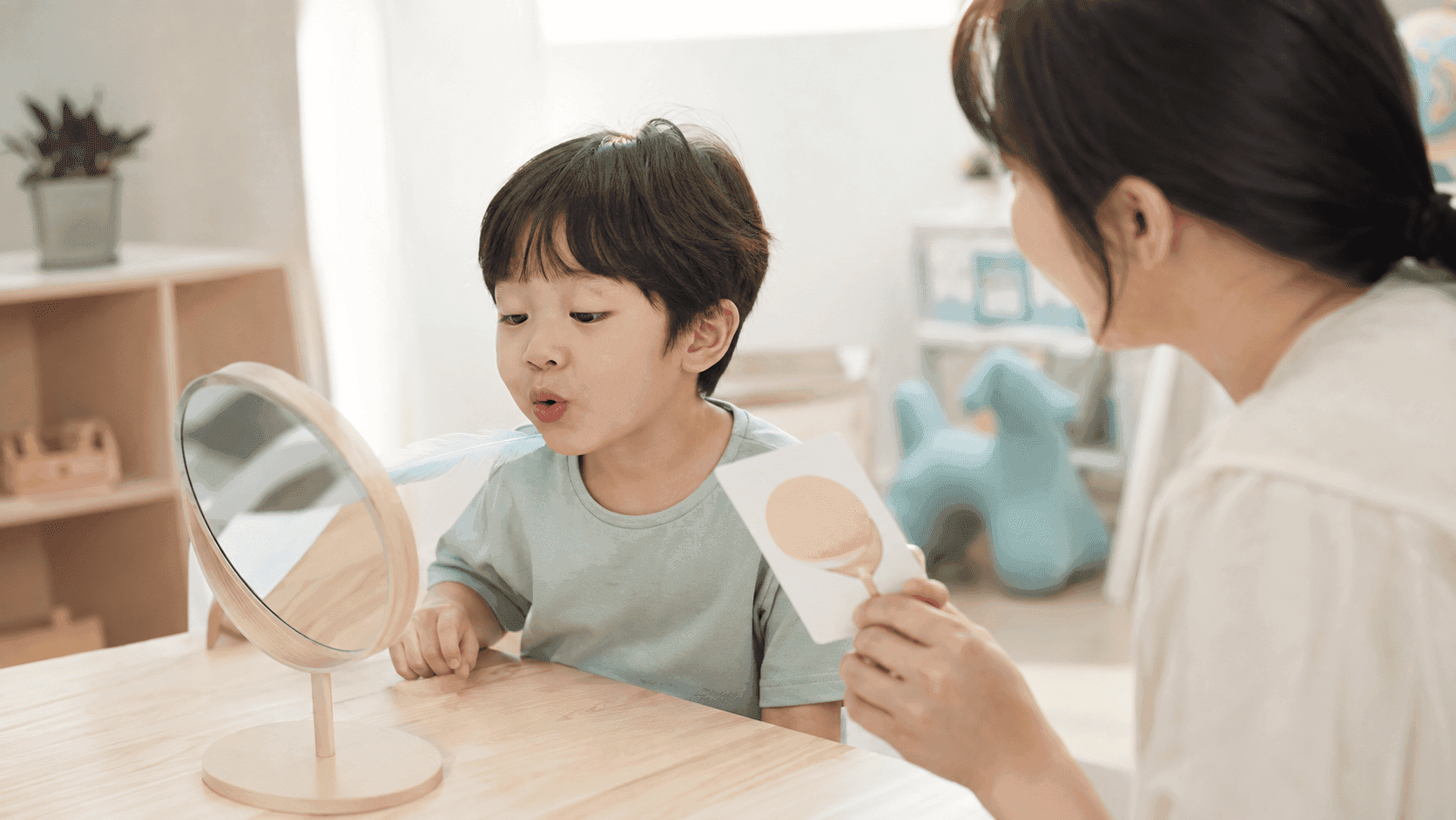 거울을 보며 입 모양과 바람 내보내기를 연습하는 4세 아이