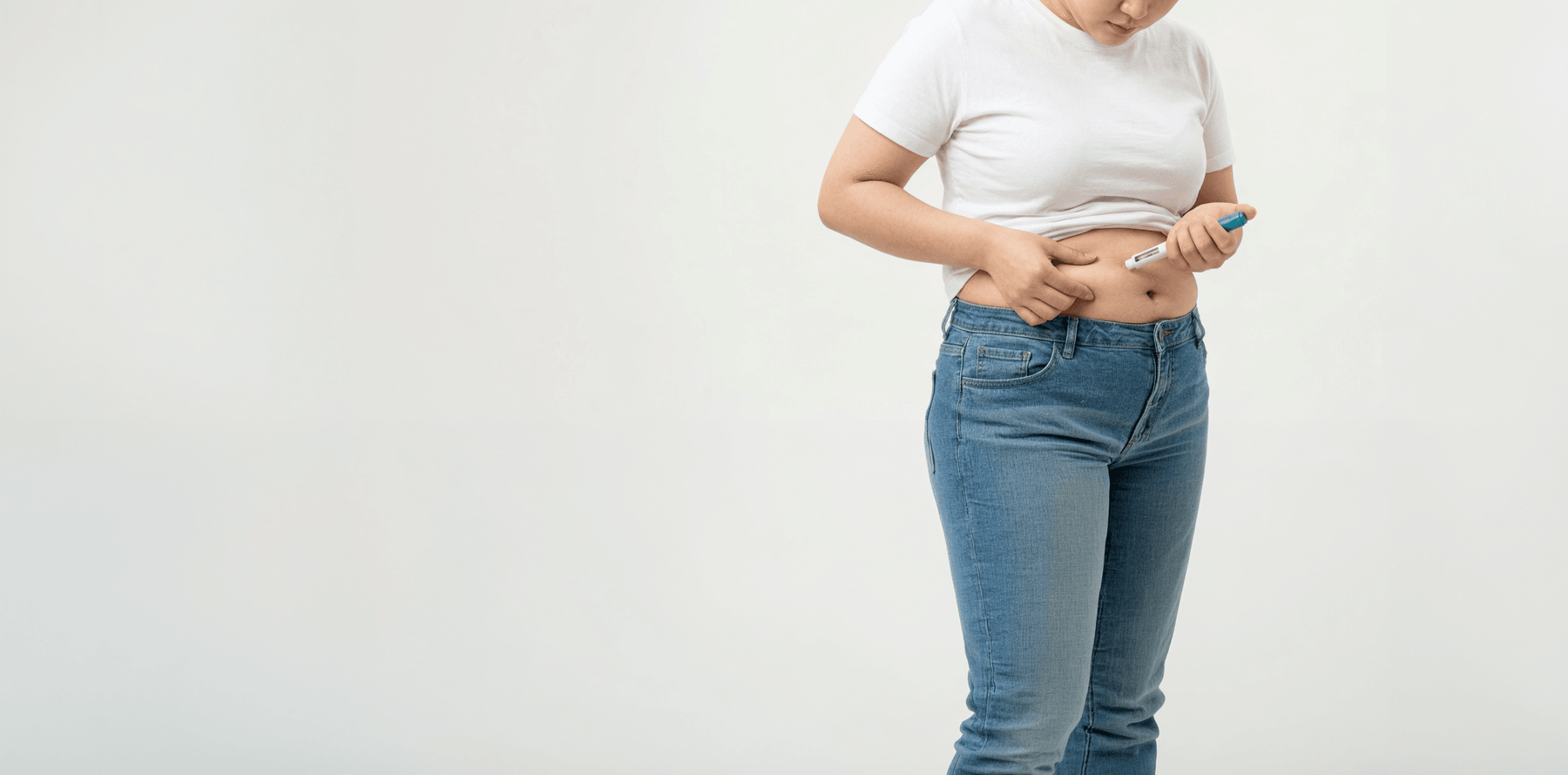 위고비 마운자로 주사 펜을 들고 배에 투여할 준비를 하는 여성
