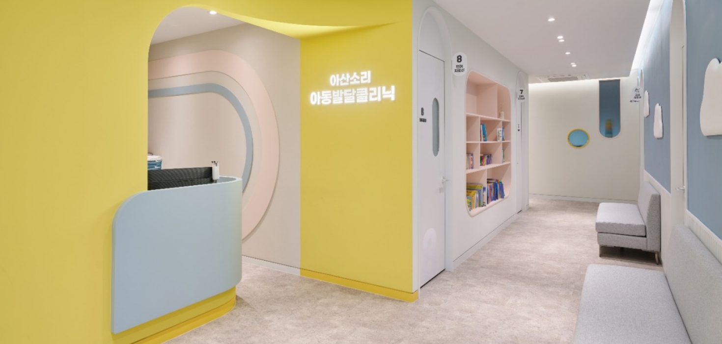 노란색과 하늘색의 파스텔톤 인테리어로 아이들에게 친근감을 주는 아산소리이비인후과 아동발달클리닉 입구와 대기 복도