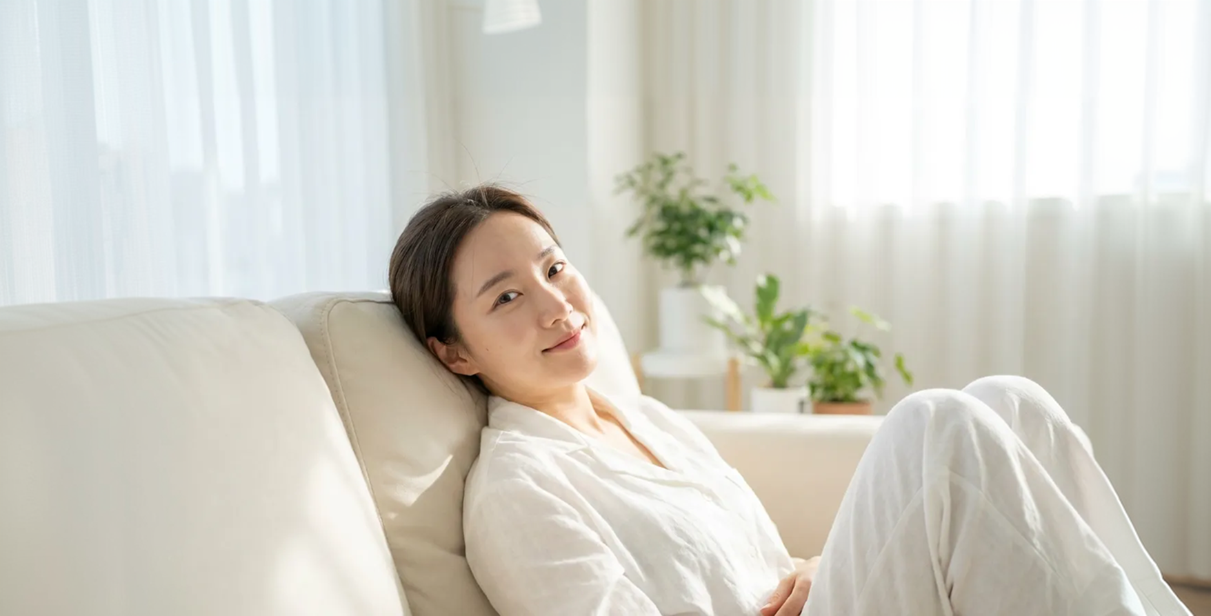 소파에 편안하게 기대어 미소 짓는 여성